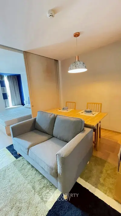 Modern living room with cozy sofa and dining area in open layout apartment.