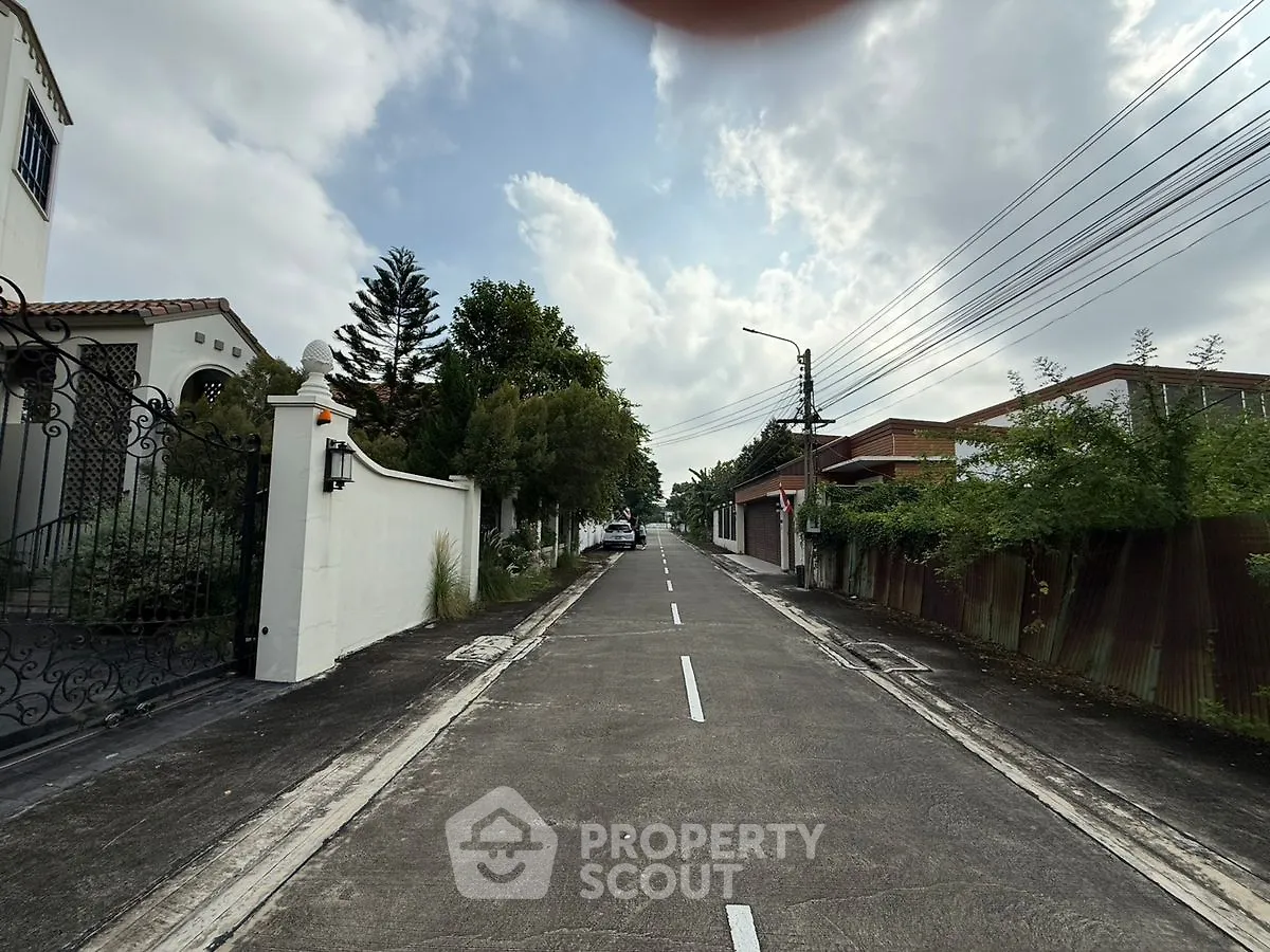 Charming residential street with lush greenery and elegant homes, perfect for serene living.