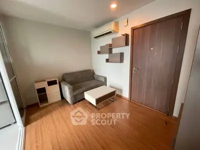 Modern living room with wooden flooring, cozy sofa, and stylish wall shelves.