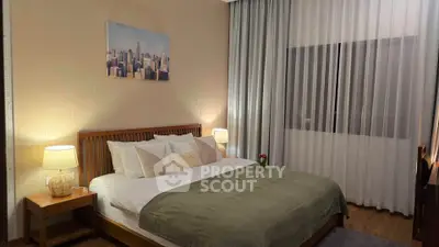 Elegant bedroom with cozy lighting and stylish decor, featuring a large bed and cityscape artwork.