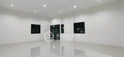 Spacious modern living room with sleek white walls and glossy tiled floor.