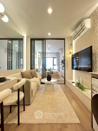 Modern living room with stylish decor and open layout, featuring a cozy sofa and wall-mounted TV.