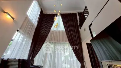 Luxurious high-ceiling living room with elegant curtains and modern lighting