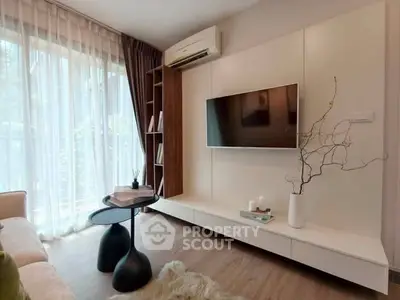 Modern living room with stylish decor, large window, and mounted TV, perfect for relaxation and entertainment.