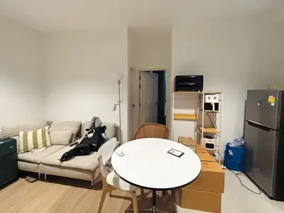 Cozy living area with modern furniture and kitchen appliances.