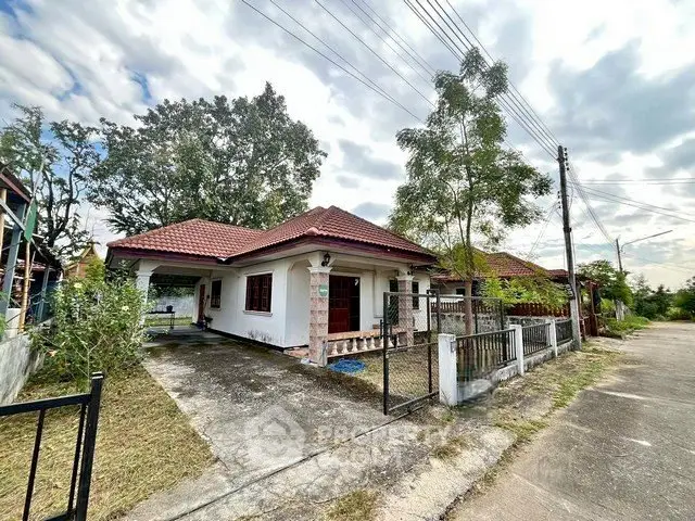 Charming single-story house with red roof and spacious driveway in a serene neighborhood.