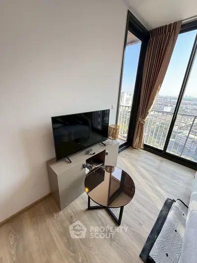 Modern living room with sleek TV setup and stunning city view from large windows.