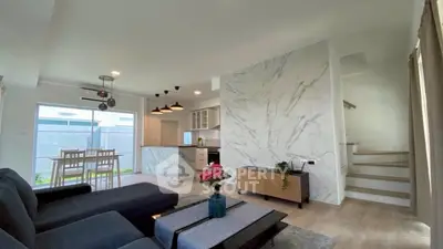Modern open-plan living room with stylish decor and natural light, featuring a cozy seating area and dining space.