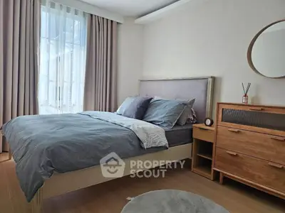 Modern bedroom with stylish decor and natural light, featuring a cozy bed and elegant wooden furniture.