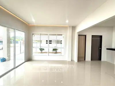 Spacious modern living room with large windows and glossy tiled floors
