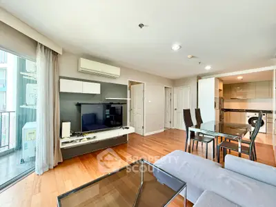 Spacious modern living room with open kitchen and balcony access