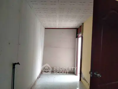 Empty room with tiled floor and open door, potential for customization.
