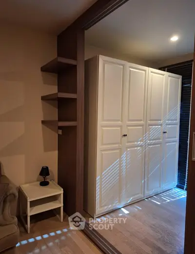 Cozy bedroom with white wardrobe and modern shelving, perfect for stylish storage solutions.