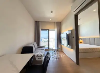 Modern apartment interior with cozy living room and bedroom, featuring stylish furniture and a scenic view.