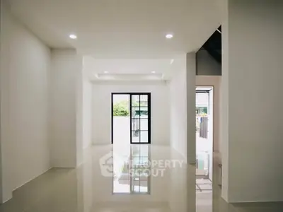 Spacious modern living room with glossy tiled floors and large windows for natural light.