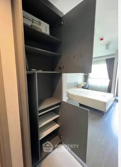 Modern bedroom with built-in storage and large window for natural light.