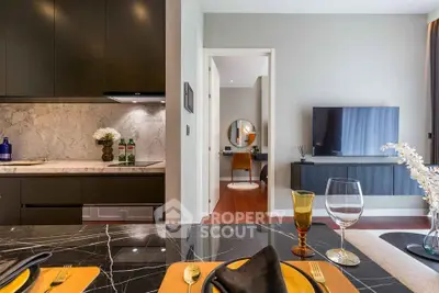 Modern open-plan kitchen and living room with elegant decor and marble countertops.