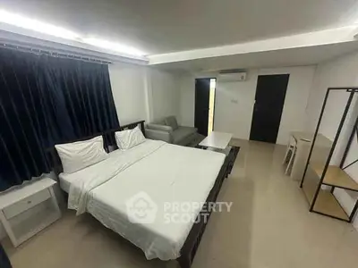 Spacious bedroom with modern furnishings and ample natural light.