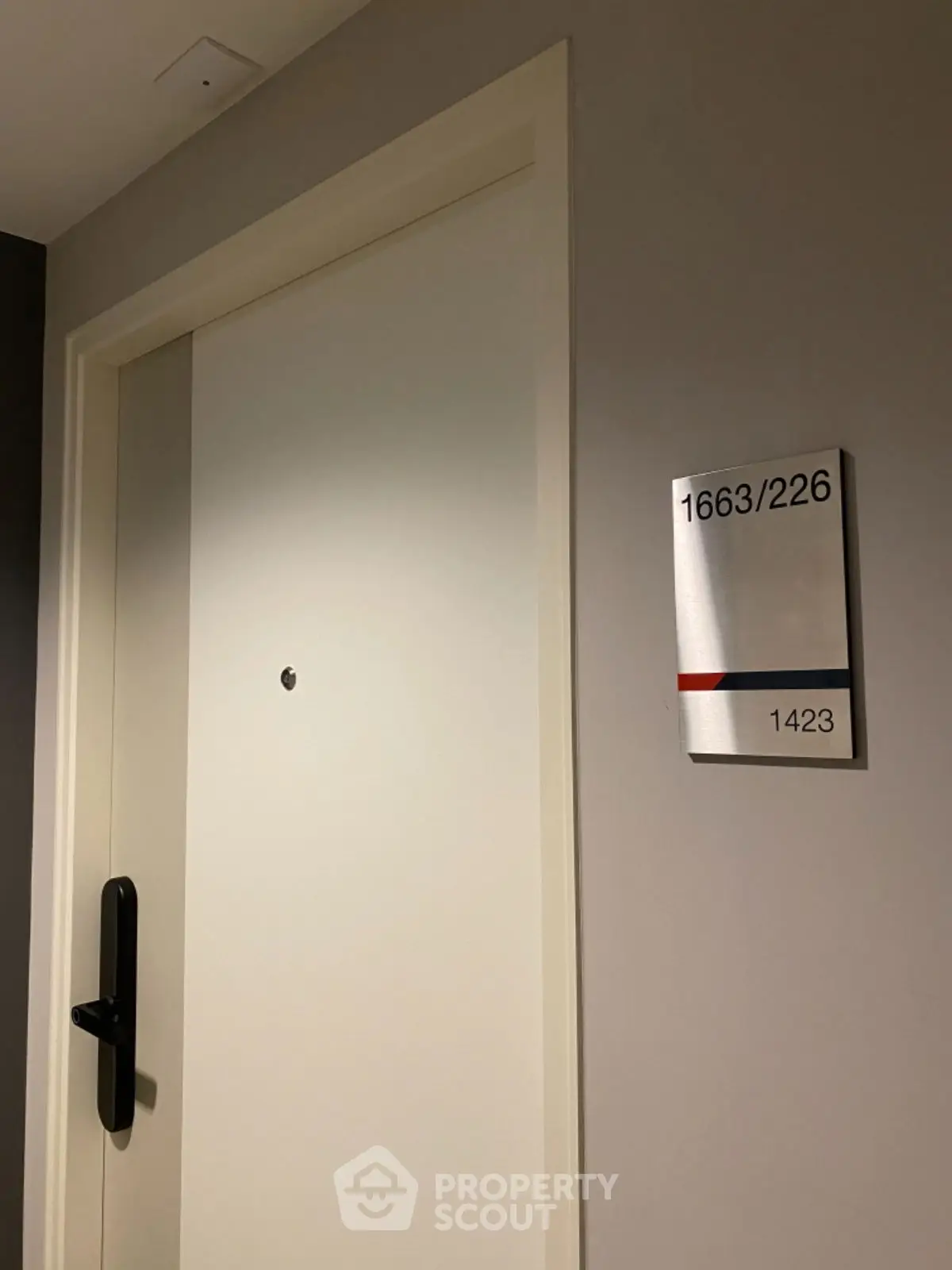 Modern apartment door with sleek handle and room number signage.