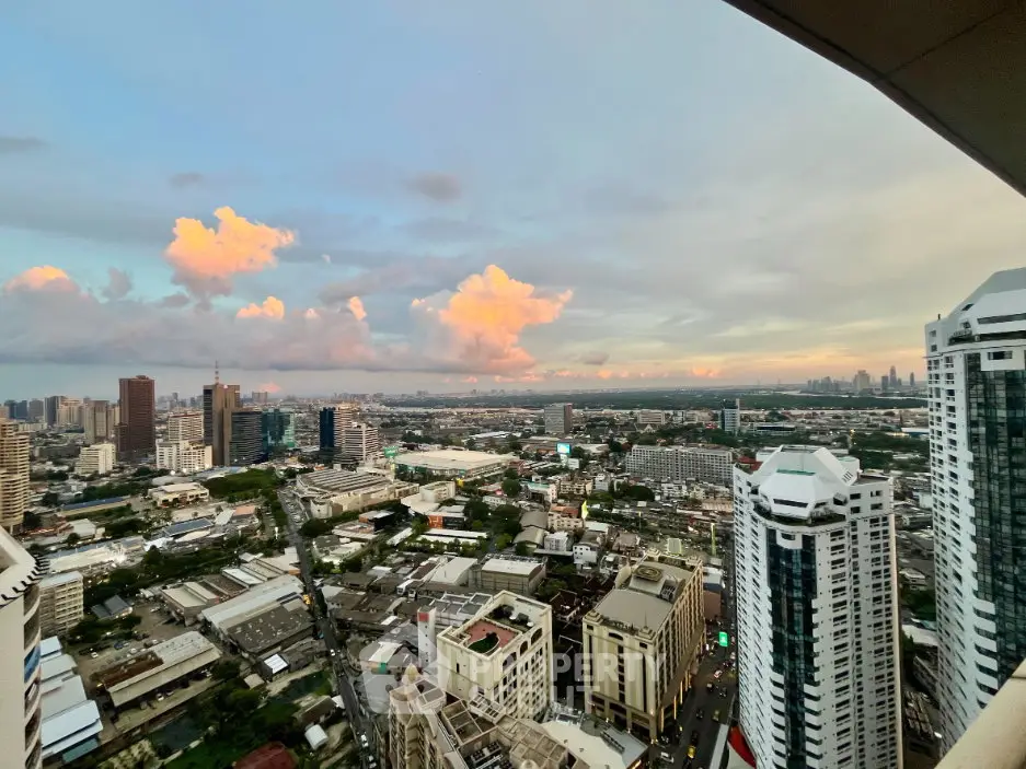 Stunning cityscape view from a high-rise building at sunset, showcasing vibrant clouds and urban skyline.
