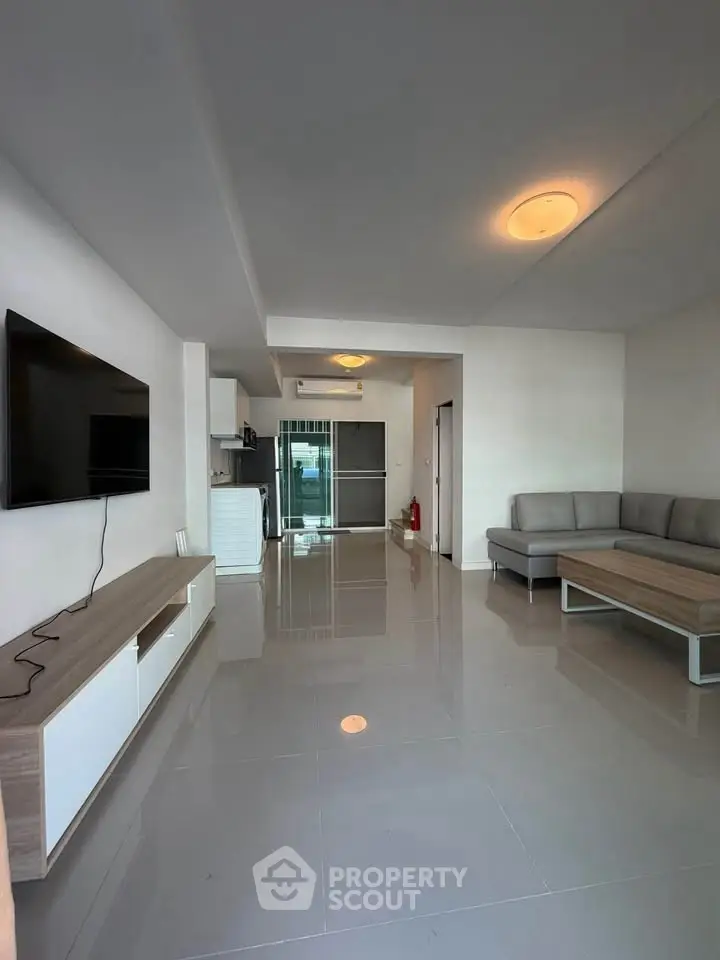 Modern living room with sleek furniture and open kitchen layout