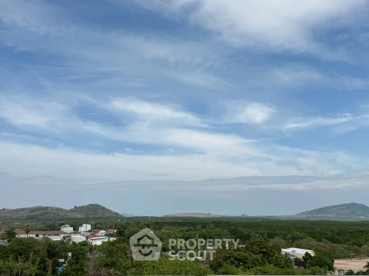 Scenic view of lush green landscape with distant hills under a clear blue sky