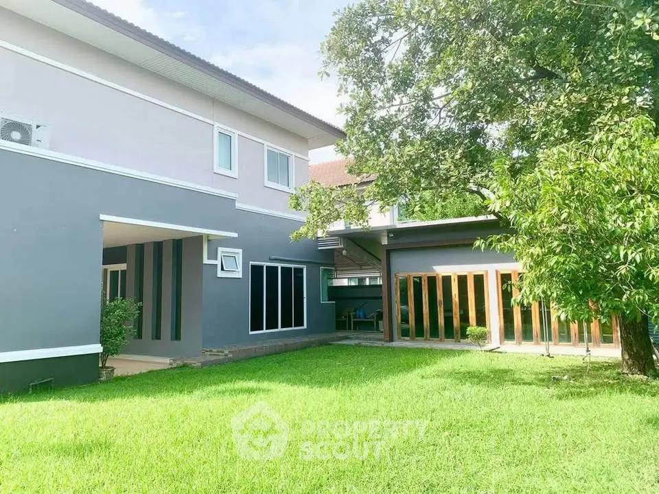 Modern two-story house with spacious green lawn and large windows