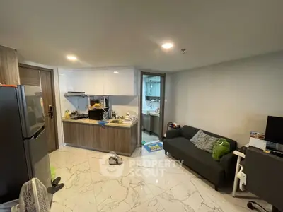 Modern open-layout kitchen with sleek cabinetry and cozy living area, perfect for urban living.