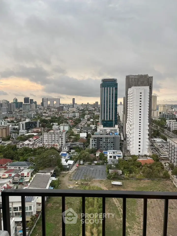 Stunning cityscape view from high-rise balcony overlooking urban skyline at sunset.