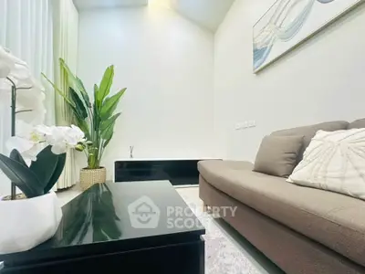 Modern living room with high ceiling, stylish sofa, and elegant decor.