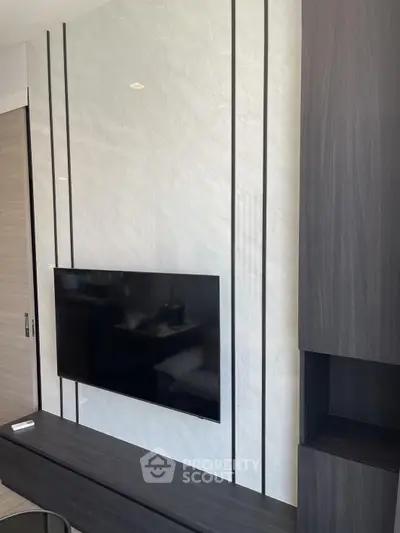 Modern living room with sleek TV setup and stylish wall paneling