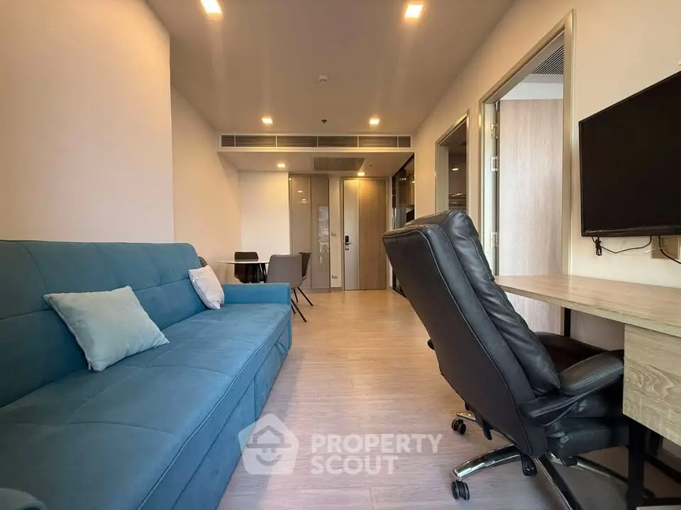 Modern living room with blue sofa and office setup, ideal for work-from-home lifestyle.