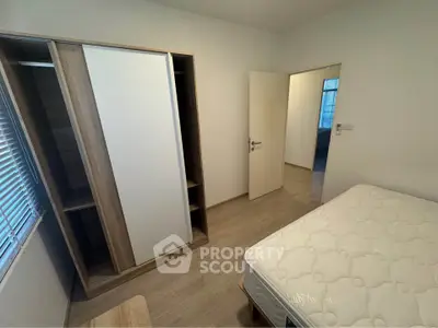 Spacious bedroom with modern wardrobe and comfortable mattress in a well-lit apartment.