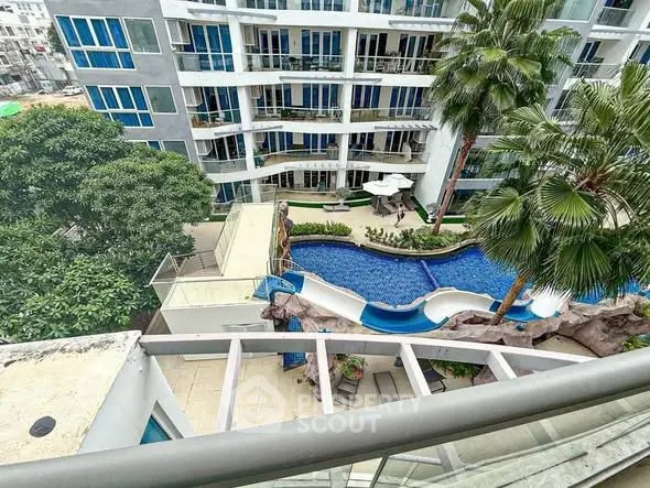 Stunning aerial view of modern apartment complex with pool and lush greenery.