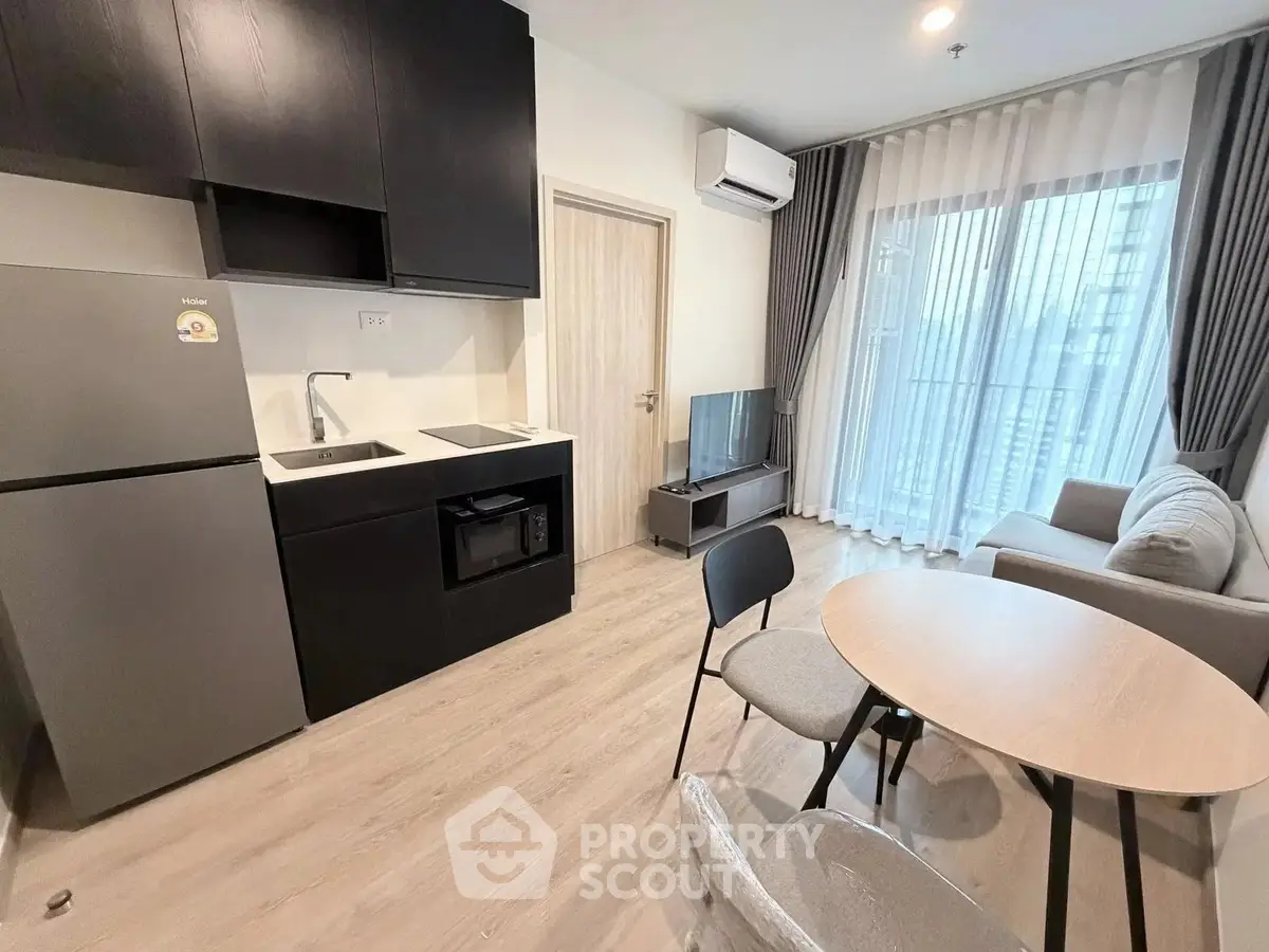 Modern apartment living room with kitchenette and balcony view