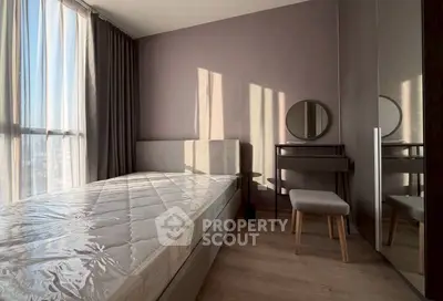 Modern bedroom with natural light, stylish furniture, and floor-to-ceiling windows.