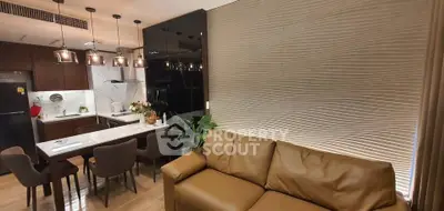 Modern open-layout kitchen and living room with stylish lighting and textured wall design.