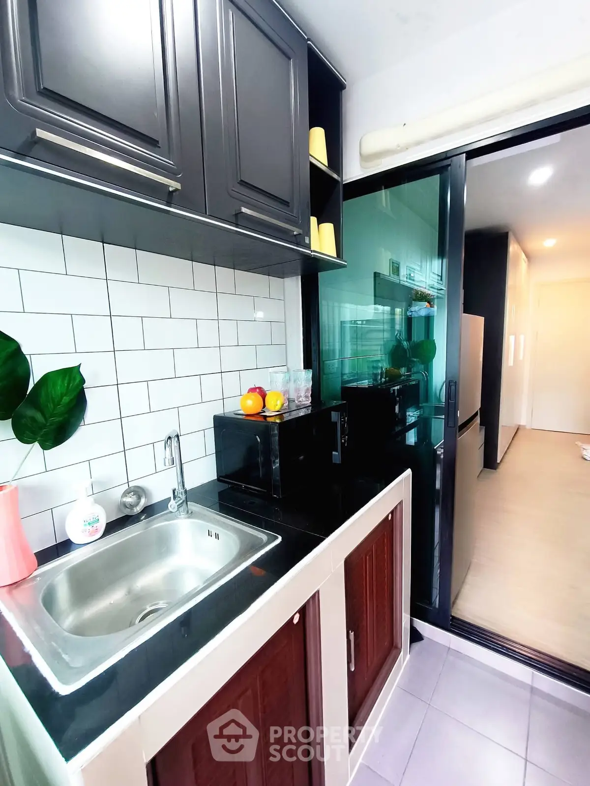 Modern kitchen with sleek cabinetry and stainless steel sink in a stylish apartment.