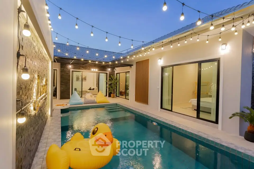 Luxurious villa with private pool and festive lighting, perfect for relaxation and entertainment.