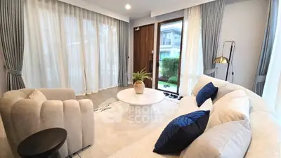 Elegant living room with plush seating and large windows overlooking garden