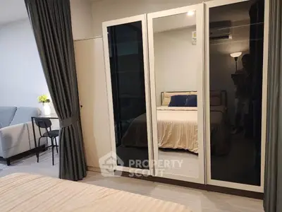 Modern bedroom with mirrored wardrobe and cozy seating area