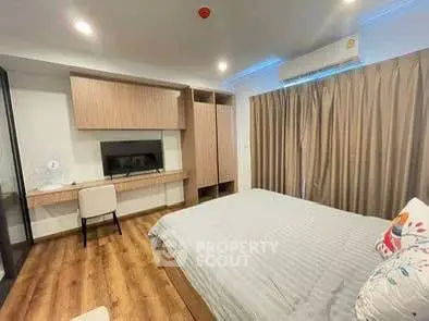 Modern bedroom with wooden flooring and built-in desk