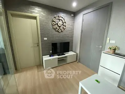 Modern living room with stylish wall clock and sleek TV setup.