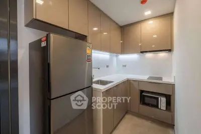 Modern kitchen with sleek cabinetry and stainless steel appliances in a compact layout.