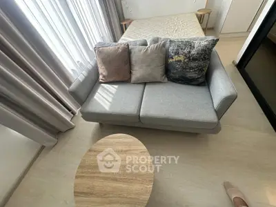 Modern living room with stylish sofa and wooden coffee table, featuring elegant decor and natural light.