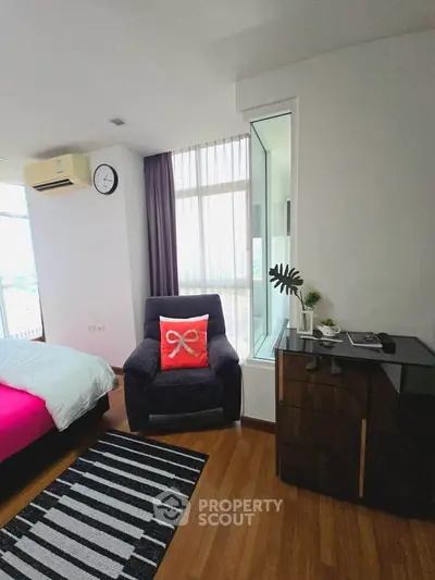 Modern bedroom with cozy armchair and stylish decor in a bright apartment.