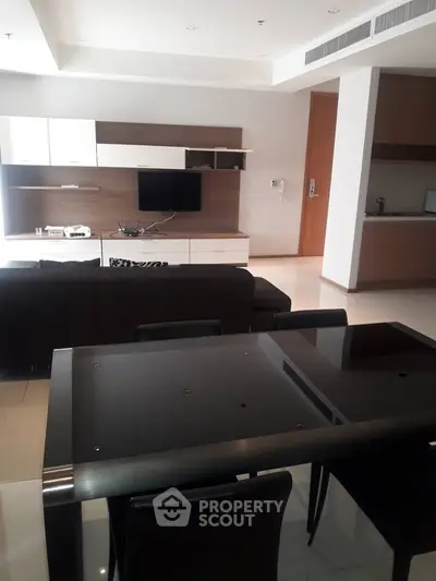 Modern living room with sleek furniture and open kitchen layout in a stylish apartment.