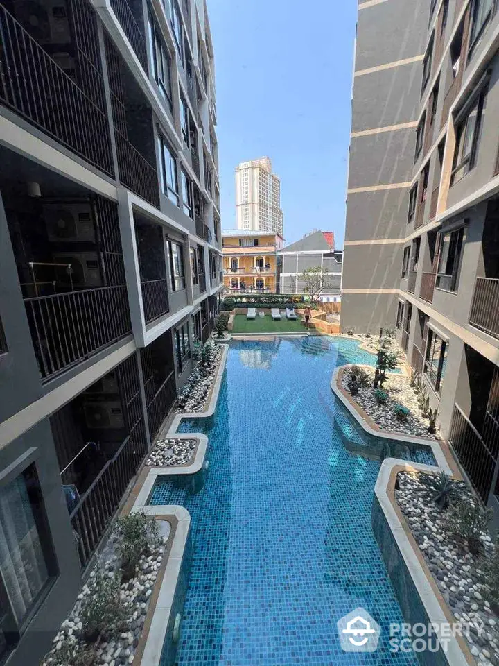 Luxurious apartment complex with a stunning central pool and modern architecture, perfect for urban living.