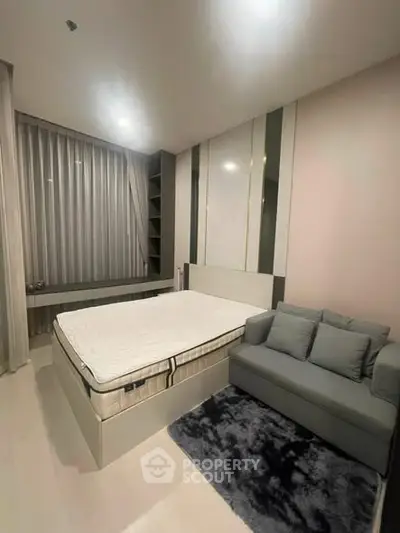 Modern bedroom with cozy sofa and stylish decor, perfect for relaxation and comfort.