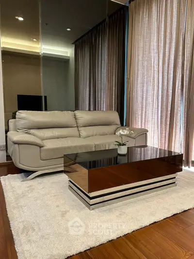 Luxurious living room with modern sofa and sleek coffee table on elegant rug.